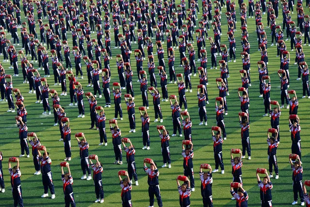 Students perform with waist drums on a school field during the opening ceremony of a sports meeting in Xiangyang, Hubei province, China November 8, 2017. (Photo by Reuters/China Daily)