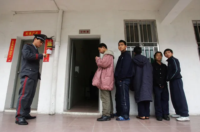 Chinese kids wait to see a doctor outside an infirmary at an assistance center February 23, 2005 in Shenzhen, Guangdong Province, China. (Photo by Cancan Chu/Getty Images)