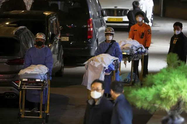 People move bodies to be transported from hospital, after a stampede during a Halloween festival in Seoul, South Korea on October 30, 2022. At least 151 people were killed and 82 people were injured in the incident in Seoul's Itaewon area, which had been packed with crowds ahead of the Monday holiday, officials said. (Photo by Kim Hong-ji/Reuters)