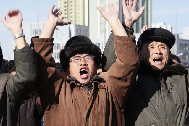 People cheer as they watch the news broadcast announcing North Korean leader Kim Jong Un's order to test-fire the newly developed inter-continental ballistic missile Hwasong-15, Wednesday, November 29, 2017, at the Pyongyang Train Station in Pyongyang, North Korea. (Photo by Jon Chol Jin/AP Photo)