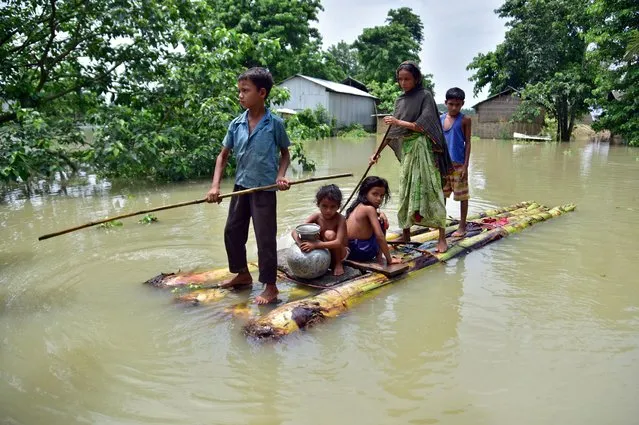Villagers row a makeshift raft through a flooded field to reach a safer place at the flood-affected Mayong village in Morigaon district, in the northeastern state of Assam, India, June 29, 2020. (Photo by Anuwar Hazarika/Reuters)