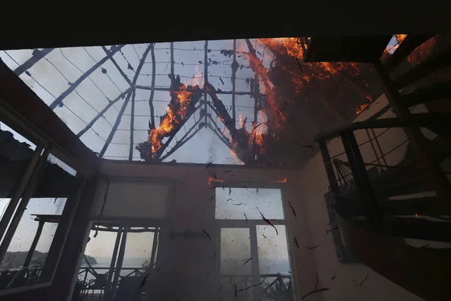 Fire burns a residence at the “Pajaro de Fuego” condominium in Sayulita, Nayarit state, Mexico, Thursday, November 30, 2017. Several condos standing at the highest point of the property went up in flames at the complex that's rented mainly to tourists, where according to ground workers, the homes operate without electricity. (Photo by Marco Ugarte/AP Photo)