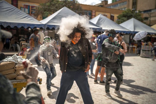 A man is attacked with talcum in “Plaza de Nariño” during “Día de Negritos” on January 5, 2024 in Pasto, Colombia. This UNESCO-recognized carnival takes place every January in the Southern Andean city of Pasto. The Carnival of “Blancos y Negros” has its origins in a mix of Amazonian, Andean and Pacific cultural expressions. Every Year the carnival brings people from all Colombia and thousands of tourists from abroad the country. (Photo by Diego Cuevas/Getty Images)
