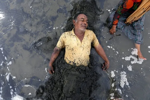 Man who suffered a stroke is buried in black sand as a part of a treatment against a stroke in Syaih Kuala beach, Banda Aceh, Indonesia, 30 August 2016. Local people believe that bathing in the in the black sand can prevent strokes and hypertension. (Photo by Hotli Simanjuntak/EPA)