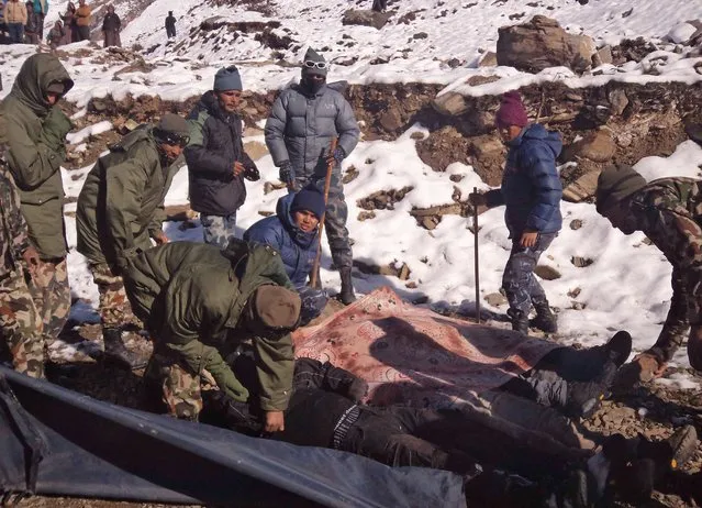 A handout picture released by the Nepalese Army shows members of the army pack dead bodies of trekkers from the Thorung La mountain pass on the Annapurna Circuit, in Mustang district, Nepal. 15 October 2014. (Photo by EPA/Nepalese Army)