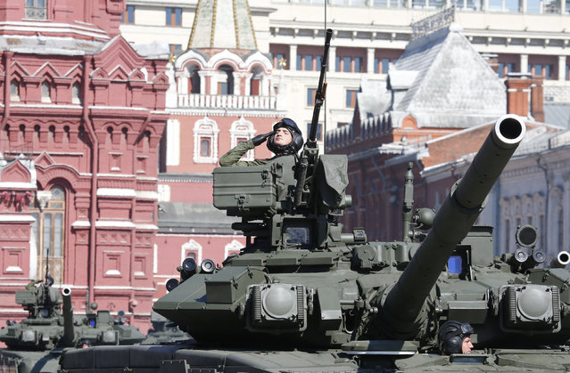 A Russian serviceman aboard a tank salutes during the Victory Day parade in Moscow's Red Square, May 9, 2014. (Photo by Grigory Dukor/Reuters)
