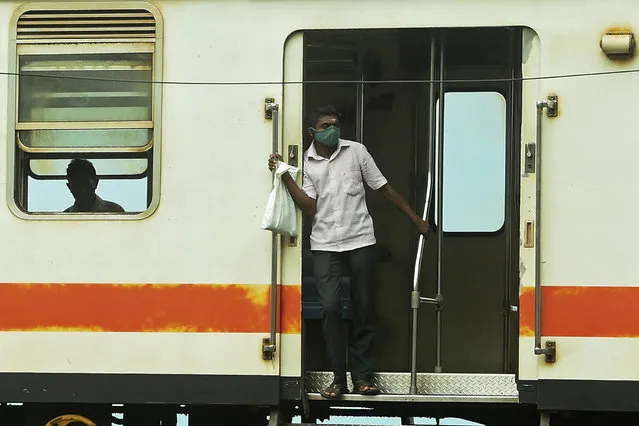 A commuter wearing a facemask as a preventive measure against the spread of the COVID-19 coronavirus, travels in a train in Colombo on July 16, 2020. (Photo by Ishara S. Kodikara/AFP Photo)