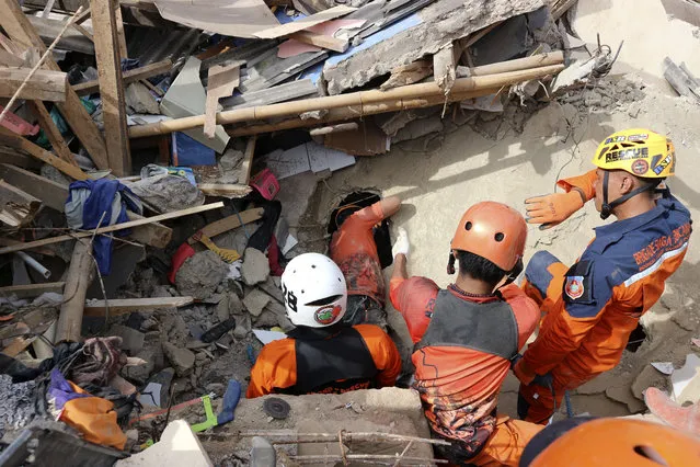 Rescuers search for victims under the rubble of a building collapsed during Monday's earthquake in Cianjur, West Java, Indonesia, Wednesday, November 23, 2022. More rescuers and volunteers were deployed Wednesday in devastated areas on Indonesia's main island of Java to search for the dead and missing from an earthquake that killed hundreds of people. (Photo by Rangga Firmansyah/AP Photo)