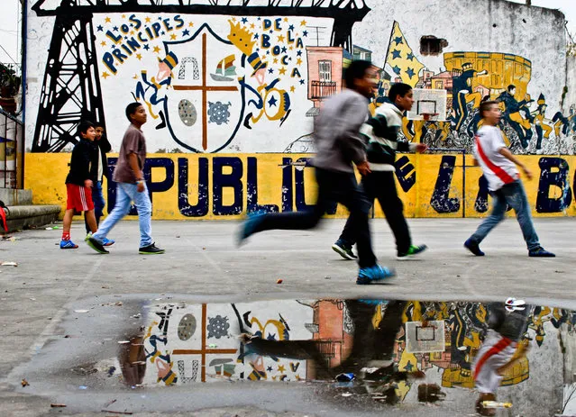 “After the Rain”. Children play a game of football after a dreary morning in La Boca. Photo location: Buenos Aires, Argentina. (Photo and caption by Rebekah Lee/National Geographic Photo Contest)