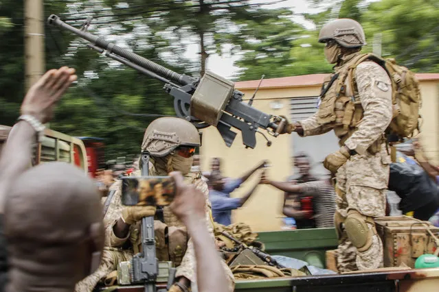 Malian soldiers parade as they arrive by military vehicle at Independence Square in Bamako on August 18, 2020, after rebel troops seized Malian President Ibrahim Boubacar Keita and Prime Minister Boubou Cisse in a dramatic escalation of a months-long crisis. Neighbouring states in West Africa, along with France, the European Union and the African Union, condemned the sudden mutiny and warned against any unconstitutional change of power in the fragile country. (Photo by AFP Photo/Stringer)