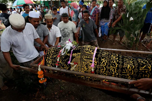 Thai Muslim villagers carry the body of a victim of a capsized boat on the Chao Phraya river, during a funeral at a graveyard in the ancient tourist city of Ayutthaya, Thailand September 19, 2016. (Photo by Chaiwat Subprasom/Reuters)