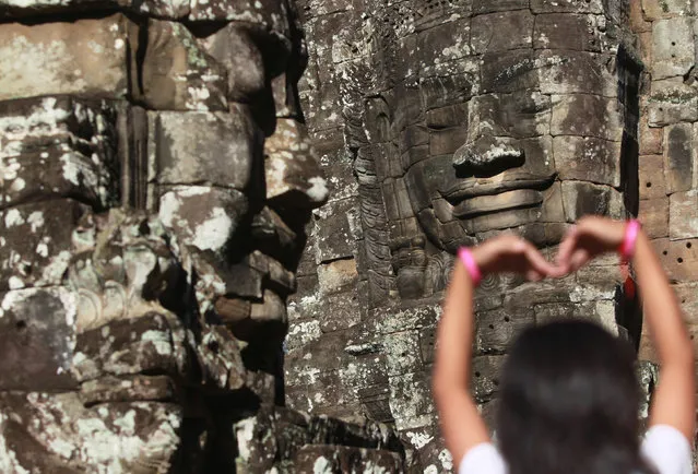 A child gestures in front of a statue inside Bayon temple complex in Siem Reap province, Cambodia, September 25, 2016. (Photo by Samrang Pring/Reuters)