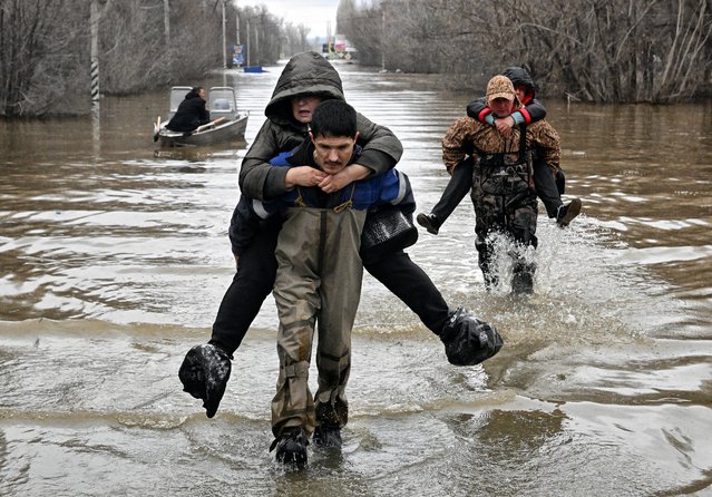 Rescuers evacuate residents from the flooded part of the city of Orsk, Russia's Orenburg region, southeast of the southern tip of the Ural Mountains on April 8, 2024. Russia said on April 8, that more than 10,000 residential buildings were flooded across the Urals, Volga area, and western Siberia as emergency services evacuated cities threatened by rising rivers. On April 7, Russia declared a federal emergency in the Orenburg region, where the Ural River flooded much of the city of Orsk and is now reaching dangerous levels in the main city of Orenburg. Much of the city of Orsk has been flooded after torrential rain burst a nearby dam. (Photo by Anatoliy Zhdanov/Kommersant Photo via AFP Photo)