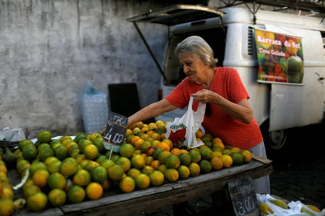A customer selects oranges at a street market in Rio de Janeiro, Brazil, May 6, 2016. (Photo by Pilar Olivares/Reuters)