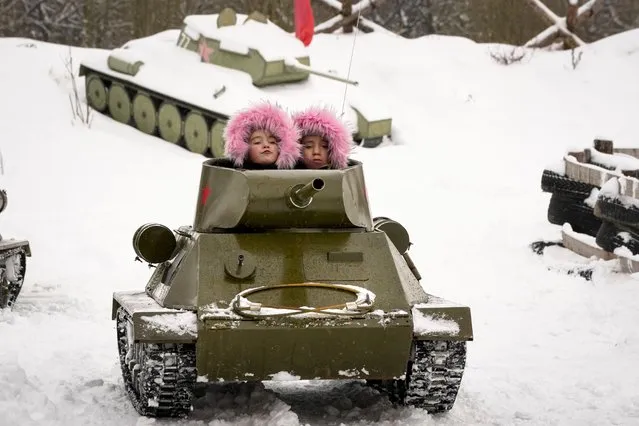 Children ride a model of World War II-era Soviet T-34 tank during a military historical festival at the family historical tank park outside St. Petersburg, Russia, Saturday, February 4, 2023. (Photo by Dmitri Lovetsky/AP Photo)