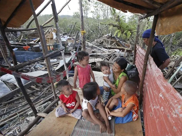 A family stays in a makeshift shelter next to the remains of houses destroyed during the onslaught of Typhoon Hagupit in San Julian, eastern Samar, in central Philippines December 9, 2014. (Photo by Erik De Castro/Reuters)