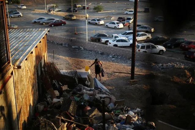 A Haitian migrant walks near garbage at the Hotel del Migrante shelter after leaving Brazil, where she relocated to after Haiti's 2010 earthquake, in Mexicali, Mexico, October 5, 2016. (Photo by Edgard Garrido/Reuters)