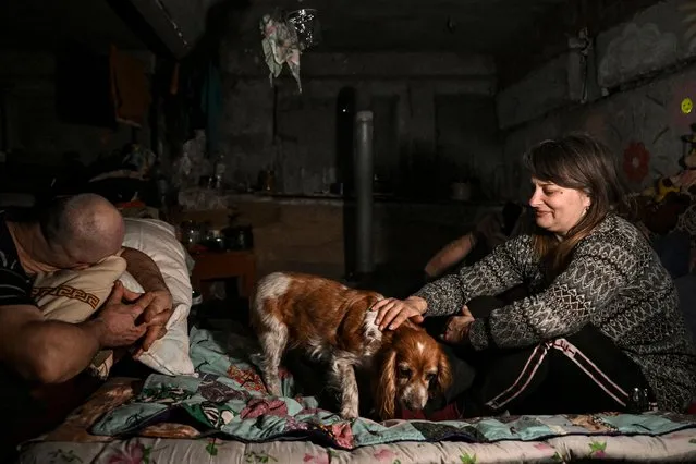 Local residents rest in a basement shelter where they take shelter and live in the village of Chasiv Yar, near the city of Bakhmut in the region of Donbas on March 5, 2023, amid the Russian invasion of Ukraine. (Photo by Aris Messinis/AFP Photo)