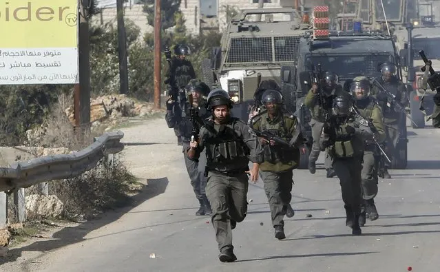 Israeli border policemen run during clashes with Palestinians in the West Bank village of Beit Ommar, north of Hebron November 3, 2015. (Photo by Mussa Qawasma/Reuters)