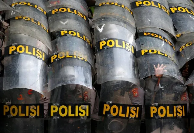 Police officers protect themselves with their shields during a protest against the new so-called omnibus law, in Jakarta, Indonesia, October 13, 2020. (Photo by Willy Kurniawan/Reuters)