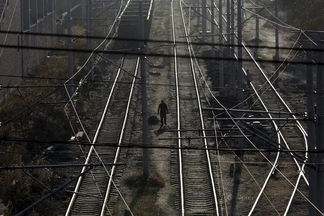 Local villagers walk along railways, which are used to transfer coal, at Zhengyang coal mine from the state-owned Longmay Group on the outskirts of Jixi, in Heilongjiang province, China, October 22, 2015. (Photo by Jason Lee/Reuters)