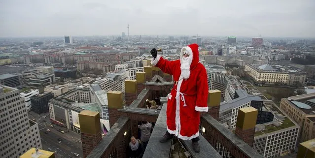 A man dressed as a Santa Claus poses on the roof of the Kollhoff Tower at Potsdamer Platz square in Berlin, December 14, 2014. (Photo by Hannibal Hanschke/Reuters)