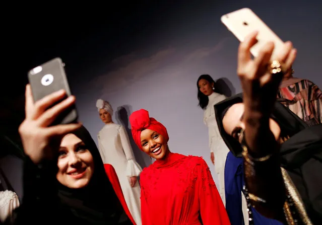 Women take selfies with Halima Aden, a hijab wearing model from the U.S., as she presents a creation by Turkish designer Rasit Bagzibagli for Modanisa during a modest fashion show in Istanbul, Turkey March 26, 2018. (Photo by Murad Sezer/Reuters)