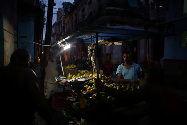 A man (R) buys fresh vegetables in downtown Havana, September 27, 2016. (Photo by Alexandre Meneghini/Reuters)