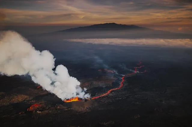 In an aerial view, lava fissures flow downslope from the north flank of Mauna Loa Volcano on December 7, 2022 in Hilo, Hawaii. For the first time in almost 40 years, the biggest active volcano in the world erupted prompting an emergency response on the Big Island. (Photo by Andrew Richard Hara/Getty Images)