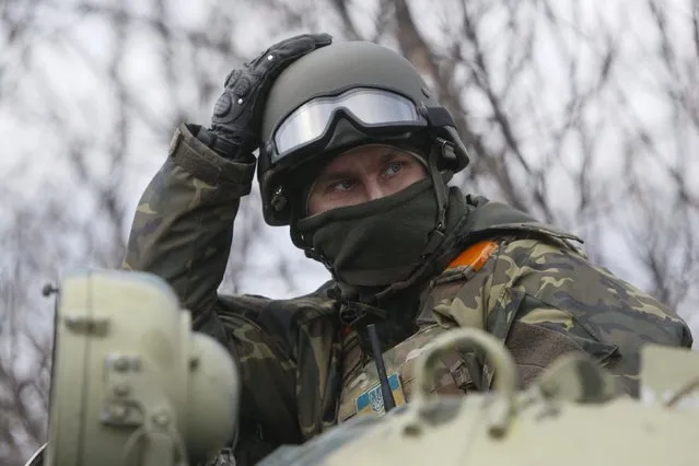 Ukrainian serviceman sits atop an armored personnel carrier (APC) at a checkpoint near the eastern Ukrainian town of Debaltseve in Donetsk region, December 24, 2014. (Photo by Valentyn Ogirenko/Reuters)