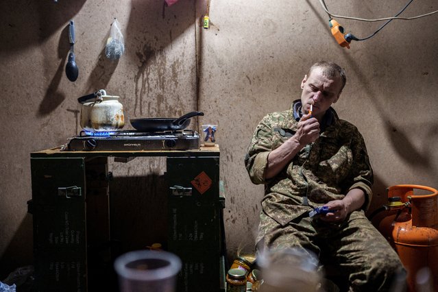 A Ukrainian service member of the 13th Operative Purpose Brigade 'Khartiia' lights a cigarette at a position in a front line in Kharkiv region, Ukraine, on July 19, 2025. (Photo by Serhii Korovainyi/Reuters)