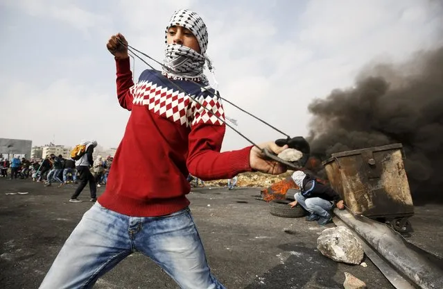 A Palestinian protester uses a sling to throw stones at Israeli troops during clashes near the Jewish settlement of Bet El, near the West Bank city of Ramallah, November 16, 2015. (Photo by Mohamad Torokman/Reuters)