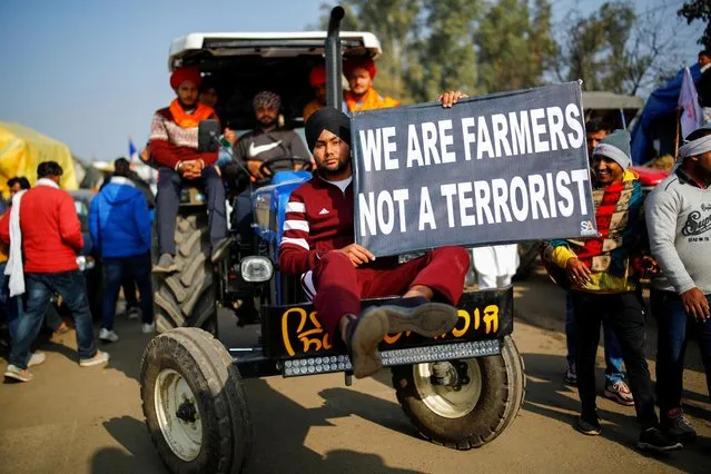 Farmers arrive in a tractor to attend a protest against the newly passed farm bills at Singhu border near New Delhi, India, December 14, 2020. (Photo by Adnan Abidi/Reuters)