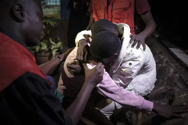 A relative of a deceased is comforted by a friend as he cries after the bodies of victims were transported into a mortuary in Nairobi, Kenya, 25 October 2016. Eleven bodies were flown in from Mandera where twelve people were killed after gunmen from Somalia's Islamist militant group al-Shabab attacked a guest house with greanades and improvised explosive device (IED)s on the same day. (Photo by Dai Kurokawa/EPA)