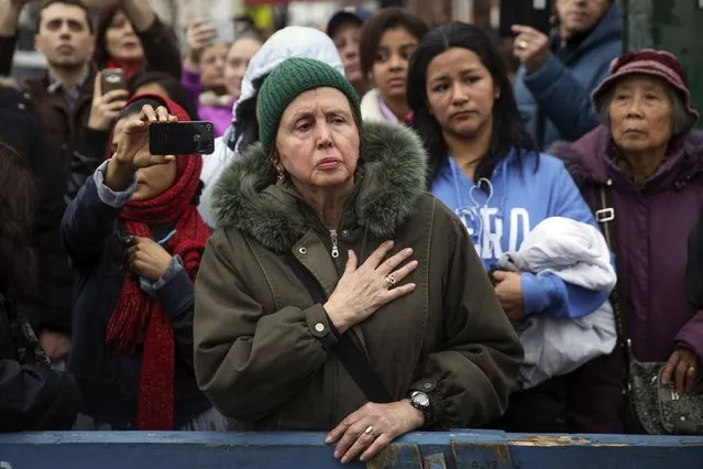 A woman puts her hand over her heart as the funeral procession for  NYPD officer Wenjian Liu leaves in the Brooklyn borough of New York January 4, 2015. (Photo by Shannon Stapleton/Reuters)