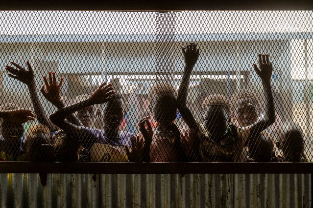 Children gather at the fenced window of a safe-space classroom managed by War Child Holland at the Renk Transit Center in Renk, South Sudan, on November 17, 2025. South Sudan's Renk Transit Center, built for 3,000, now shelters over 12,000 refugees, returnees, and deportees fleeing the Sudan war that has displaced more than 1?million people since 2023, with thousands living in makeshift tents and straining limited food, water, and medical resources. (Photo by Rian Cope/AFP Photo)
