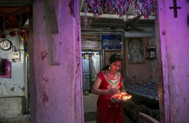 A woman holds candles as Indians celebrate the annual festival of Diwali on October 30, 2016 in Mumbai, India. Diwali, the festival of lights, is one of Hinduism's most important festivals dedicated to Lakshmi, the Hindu goddess of wealth. (Photo by Allison Joyce/Getty Images)