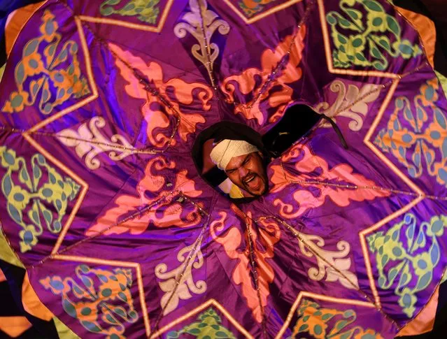 An Egyptian dancer performs the Tanoura, an Egyptian version of Sufi dance, during the holy fasting month of Ramadan, at Al Ghouri Palace in the old Islamic area of Cairo, Egypt on April 12, 2023. (Photo by Mohamed Abd El Ghany/Reuters)