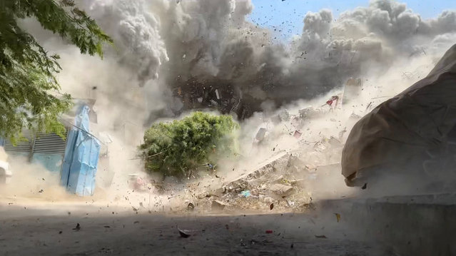 Debris flies as smoke rises from a house hit by an Israeli strike, amid the ongoing conflict between Israel and Hamas, in Nuseirat refugee camp, in the central Gaza Strip, in this still picture taken from a video August 27, 2024. (Photo by Reuters TV)