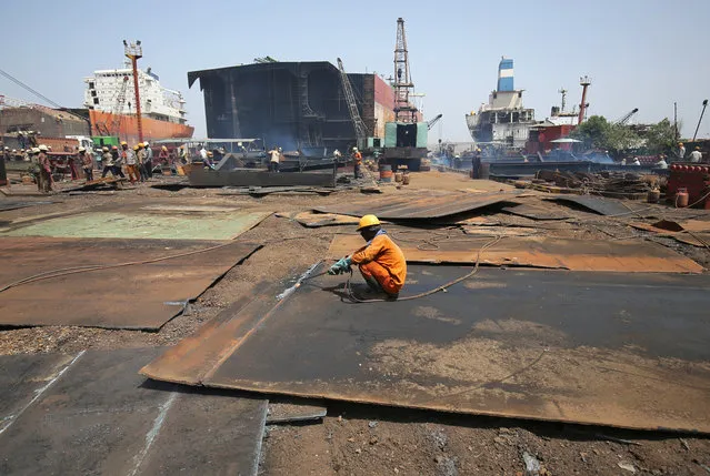 Workers dismantle a decommissioned ship at the Alang shipyard in Gujarat, India, May 29, 2018. (Photo by Amit Dave/Reuters)