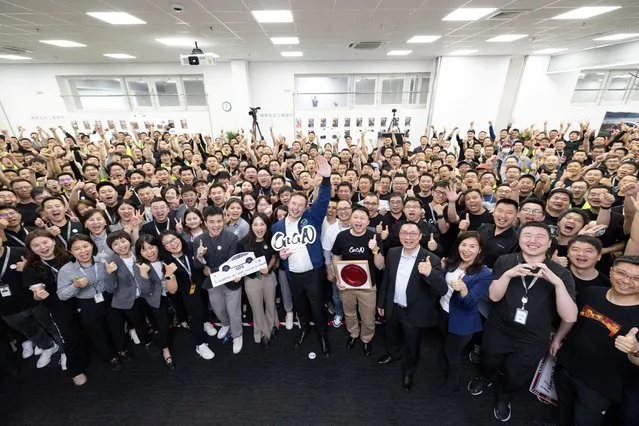 Tesla Chief Executive Officer Elon Musk poses for a group photo at the Shanghai Gigafactory of the U.S. electric vehicle maker in Shanghai, China, in this handout image released on June 1, 2023. (Photo by Tesla/Handout via Reuters)