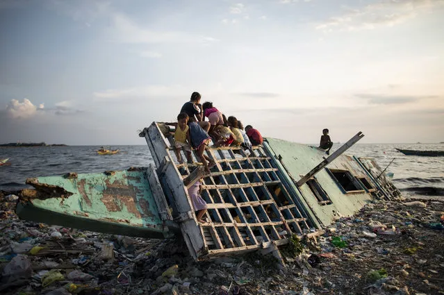 Children play on a wooden boat in Manila Bay on May 10, 2018. The Philippine economy grew by 6.8 percent from a year earlier in the three months to March, in line with most expectations though there are rising concerns over inflation, the government said on May 10. (Photo by Noel Celis/AFP Photo)