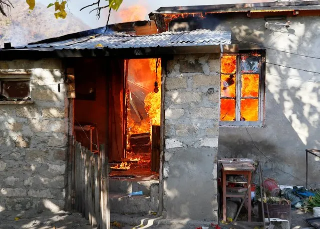 A house is set on fire by departing ethnic Armenians in the village of Cherektar, November 14, 2020. Nestled in the mountains, Charektar is a small village in the Kalbajar district of Azerbaijan, which borders Nagorno-Karabakh. It is internationally recognized as part of Azerbaijan, but has been controlled by ethnic Armenians since a war over Nagorno-Karabakh in the 1990s. On Sunday, the Azeris were set to return and take back control of the area. (Photo by Reuters/Stringer)
