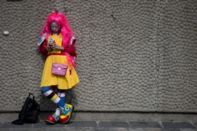 A clown checks her phone as she waits outside the Basilica of Our Lady of Guadalupe, in Mexico City, Monday, December 14, 2015. (Photo by Rebecca Blackwell/AP Photo)