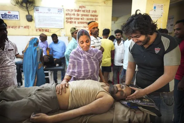 Meena Tiwari, center, cries standing in front of the body of her son Ashutosh Tiwari, who allegedly died of heat stroke, at the district government hospital, in Ballia district of northern Indian state of Uttar Pradesh, Monday, June 19, 2023. Nearly 170 people have died in the last few days in northern India as searing heat combined with lack of preparedness and resources at local hospitals is resulting in a constantly increasing body count. According to local news reports and health officials in Uttar Pradesh state, 119  people have died and in neighboring Bihar state, government officials say 47 people have died due to heat-related illness. (Photo by Rajesh Kumar Singh/AP Photo)