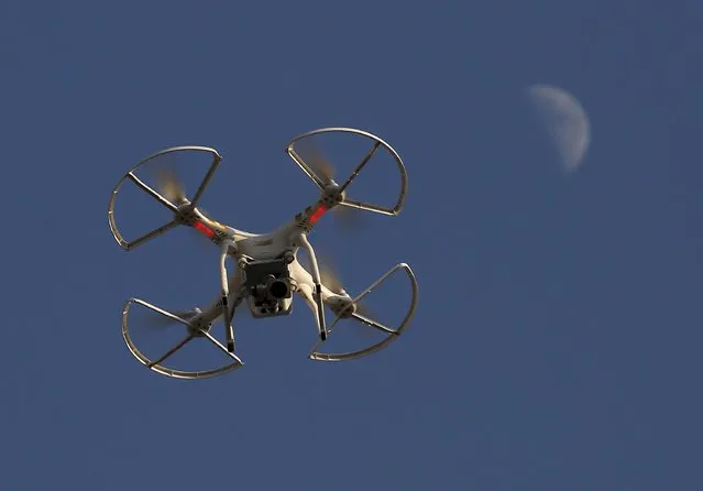 A drone, flown by Michael Perry, Director of Strategic Partnerships of DJI, is seen in front of the moon in Shenzhen, China December 18, 2015, two days before the opening of DJI's first flagship store. Chinese drone developers are racking up an impressive list of aerial solutions for a growing variety of demands, from police surveillance to agricultural mapping and traffic management. Already well established as a world leader in drone manufacturing, China is slowly emerging as a world-class innovator, not just a duplicator of foreign designs. (Photo by Bobby Yip/Reuters)