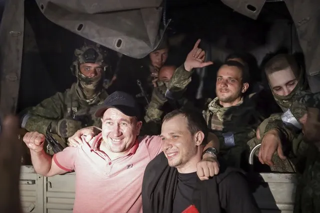 Two local men pose for a photo with servicemen of the Wagner Group military company sitting in their military vehicle on a street in Rostov-on-Don, Russia, Saturday, June 24, 2023, as they prepare to leave an area at the headquarters of the Southern Military District. (Photo by AP Photo/Stringer)