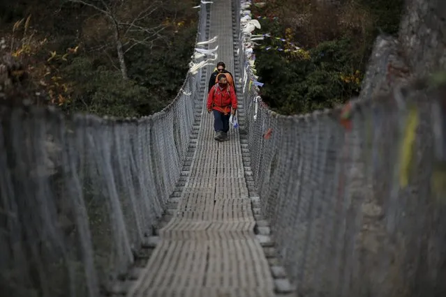 A guide leads a trekker through a suspension bridge in Solukhumbu district, also known as the Everest region, in this picture taken November 28, 2015. (Photo by Navesh Chitrakar/Reuters)