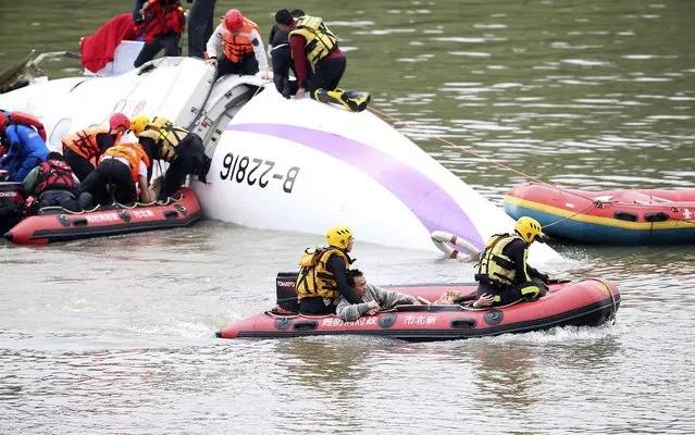 Rescue personnel transport passengers to land after a TransAsia Airways plane crash landed in a river in New Taipei City, February 4, 2015. (Photo by Reuters/Stringer)