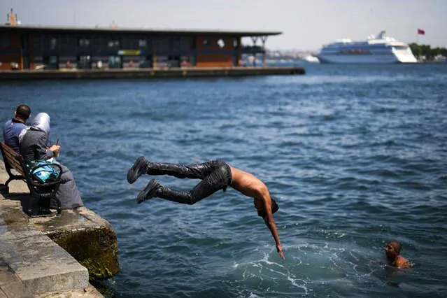 Youngster dive into the Bosphorus next to Karakoy ferry terminal on a hot summer day in Istanbul, Turkey, Thursday, July 6, 2023. (Photo by Francisco Seco/AP Photo)